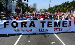 Residents of Rio de Janeiro demonstrate against interim president Michel Temer, political upheaval, corruption and the cost of the Rio 2016 Olympics Games, in front of the Copacabana Palace Hotel on August 5, 2016. Thousands of Brazilians angry at political upheaval, corruption and the cost of the Rio Olympics blocked traffic in protests hours before the gala opening ceremony. Most people came to vent anger at center-right interim president Michel Temer who took power in May on the suspension of the elected leftist president, Dilma Rousseff, for an impeachment trial that her supporters claim amounts to a coup.